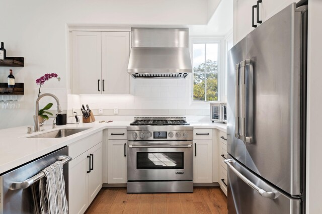3736 State St Unit 109, Santa Barbara, CA 93105 - kitchen with high end appliances, wall chimney exhaust hood, a sink, light countertops, and backsplash