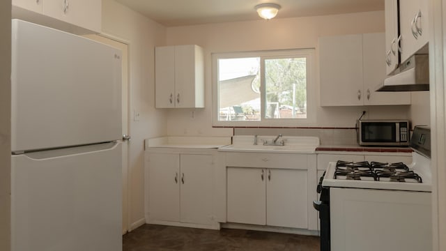 4810 Cebrian Ave, New Cuyama, CA 93254 - kitchen featuring freestanding refrigerator, gas range oven, stainless steel microwave, under cabinet range hood, and white cabinetry