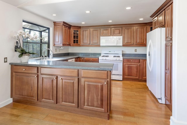 5150 Concord Pl, Carpinteria, CA 93013 - kitchen with white appliances, a sink, a peninsula, light wood-style flooring, and brown cabinets