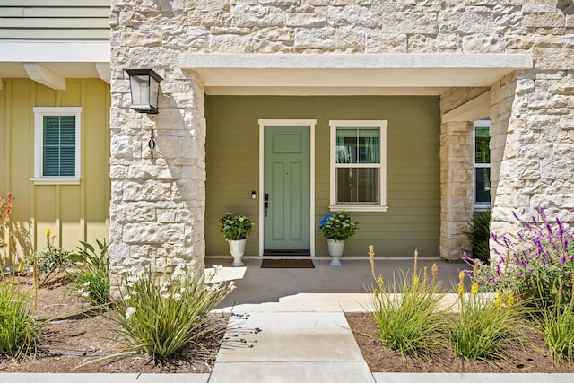 5696 Surfrider Way Unit 101, Goleta, CA 93117 - doorway to property with board and batten siding, stone siding, and covered porch