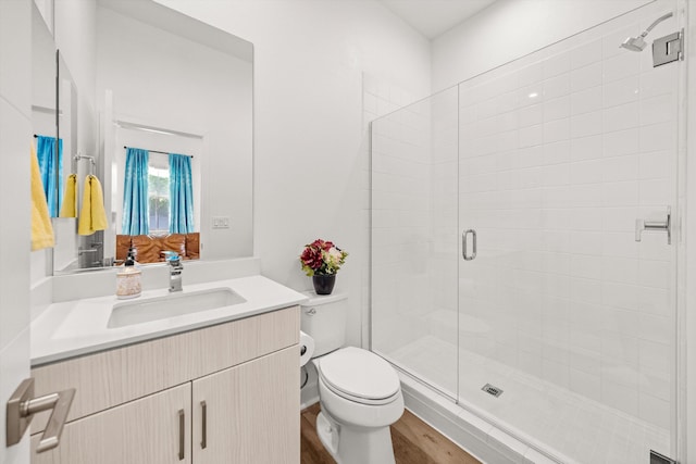 5696 Surfrider Way Unit 101, Goleta, CA 93117 - bathroom featuring toilet, a shower stall, vanity, and wood finished floors