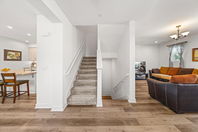 5696 Surfrider Way Unit 101, Goleta, CA 93117 - staircase with wood finished floors, recessed lighting, and a chandelier