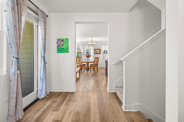 5696 Surfrider Way Unit 101, Goleta, CA 93117 - entryway featuring light wood-style floors, a chandelier, stairs, and baseboards