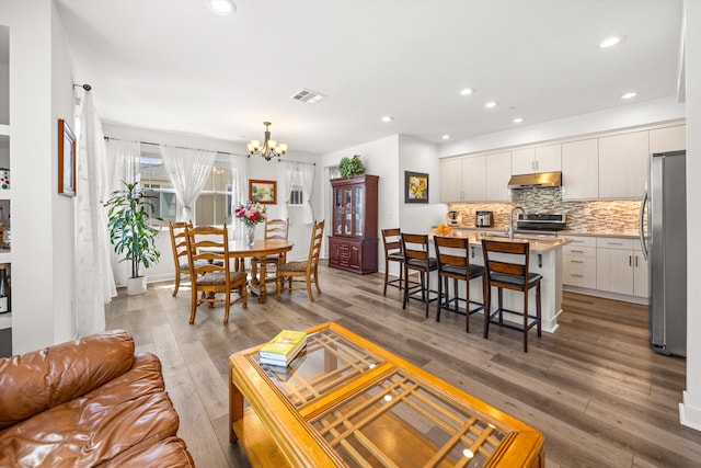 5696 Surfrider Way Unit 101, Goleta, CA 93117 - living room featuring a chandelier, light wood finished floors, and recessed lighting