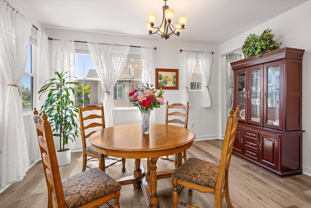5696 Surfrider Way Unit 101, Goleta, CA 93117 - dining area featuring a chandelier, light wood-style flooring, and baseboards