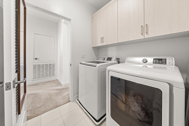5696 Surfrider Way Unit 101, Goleta, CA 93117 - washroom featuring cabinet space, washer and dryer, light carpet, and light tile patterned floors