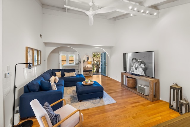 2648 State St Unit 32, Santa Barbara, CA 93105 - living area featuring arched walkways, beam ceiling, light wood-style flooring, ceiling fan, and a towering ceiling