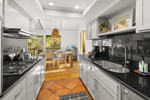 2648 State St Unit 32, Santa Barbara, CA 93105 - kitchen with a sink, stainless steel appliances, open shelves, decorative backsplash, and dark stone counters