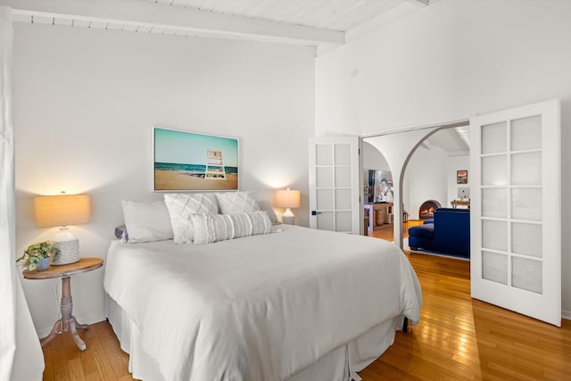 2648 State St Unit 32, Santa Barbara, CA 93105 - bedroom featuring beam ceiling, french doors, wood finished floors, arched walkways, and high vaulted ceiling