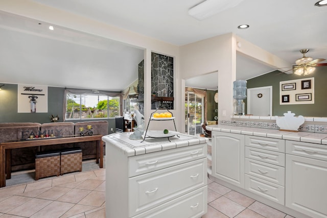 5671 Cathedral Oaks Rd, Goleta, CA 93117 - kitchen featuring vaulted ceiling, tile countertops, light tile patterned flooring, white cabinetry, and a ceiling fan