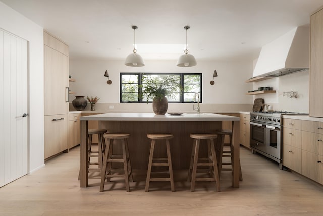 99 Sierra Vista Rd, Santa Barbara, CA 93108 - kitchen featuring range with two ovens, wall chimney exhaust hood, modern cabinets, open shelves, and a breakfast bar area