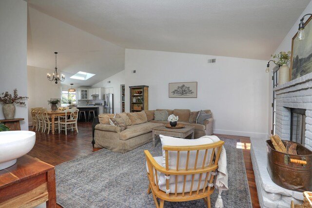 227 Menlo Dr, Buellton, CA 93427 - living room with wood finished floors, a chandelier, a fireplace, a skylight, and baseboards