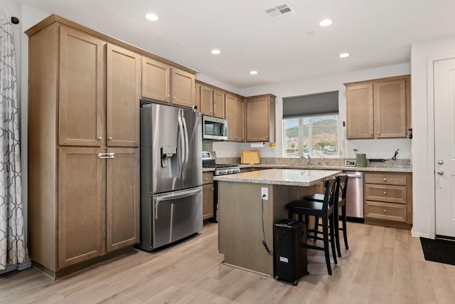 1926 Pump House Ln, Santa Paula, CA 93060 - kitchen with stainless steel appliances, a center island, light wood-type flooring, recessed lighting, and a breakfast bar area