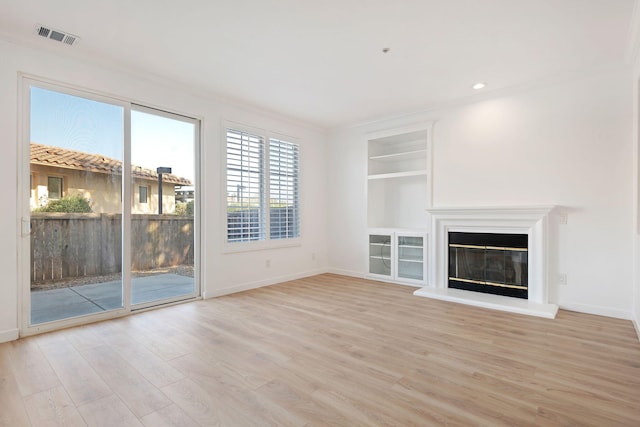 598 Poppyfield Pl, Goleta, CA 93117 - unfurnished living room featuring light wood-style flooring, baseboards, built in shelves, and a glass covered fireplace