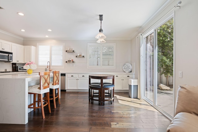 4538 Marrisa Way, Camarillo, CA 93012 - kitchen with crown molding, stainless steel appliances, a breakfast bar area, white cabinetry, and dark wood finished floors