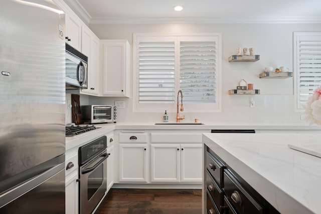 4538 Marrisa Way, Camarillo, CA 93012 - kitchen with appliances with stainless steel finishes, a sink, ornamental molding, white cabinetry, and dark wood-type flooring