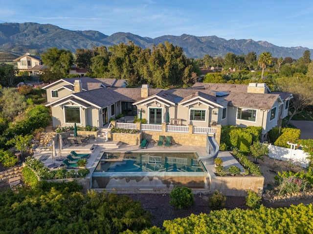 4900 Via Los Santos, Santa Barbara, CA 93111 - back of house featuring an outdoor pool, a patio, a chimney, and a mountain view