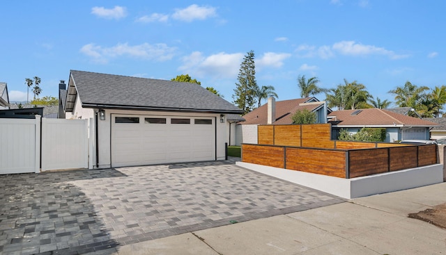 7352 Elmhurst Pl, Goleta, CA 93117 - view of front facade featuring decorative driveway, a fenced front yard, a shingled roof, and stucco siding