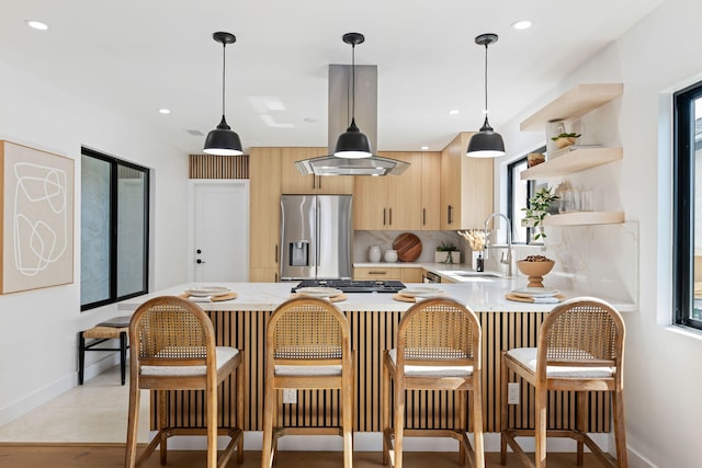 7352 Elmhurst Pl, Goleta, CA 93117 - kitchen featuring stainless steel appliances, light brown cabinets, light countertops, a peninsula, and island range hood