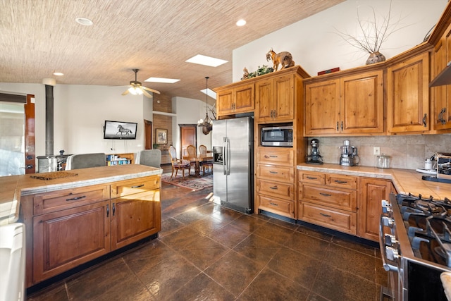 13750 Cuyama Hwy, Cuyama, CA 93461 - kitchen featuring stainless steel appliances, a ceiling fan, brown cabinets, tile countertops, and tasteful backsplash