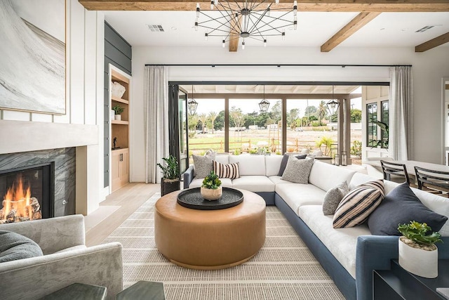 123 Polo Way, Santa Barbara, CA 93013 - living room with wood finished floors, beam ceiling, a chandelier, built in shelves, and a high end fireplace