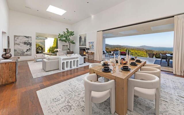 356 Woodley Rd, Montecito, CA 93108 - dining room featuring a towering ceiling, a mountain view, hardwood / wood-style floors, a lit fireplace, and a skylight