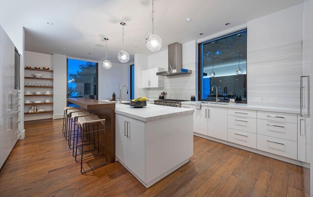 356 Woodley Rd, Montecito, CA 93108 - kitchen featuring modern cabinets, wall chimney range hood, dark wood finished floors, decorative backsplash, and white cabinets