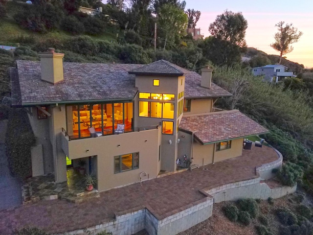 62 Canon View Rd, Montecito, CA 93108 - back of property at dusk featuring a chimney, stucco siding, and a balcony