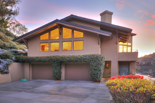 62 Canon View Rd, Montecito, CA 93108 - view of front of house with stucco siding, driveway, a garage, a balcony, and a chimney
