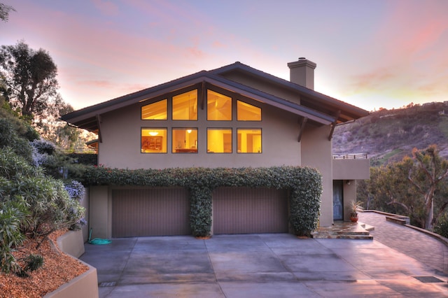 62 Canon View Rd, Montecito, CA 93108 - view of front of house with stucco siding, concrete driveway, an attached garage, and a chimney