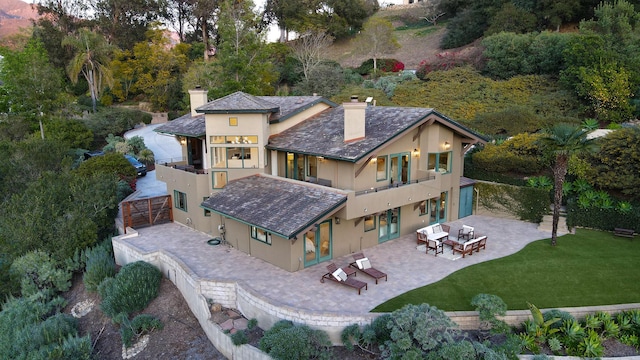 62 Canon View Rd, Montecito, CA 93108 - rear view of house with stucco siding, a chimney, a balcony, a patio area, and a high end roof