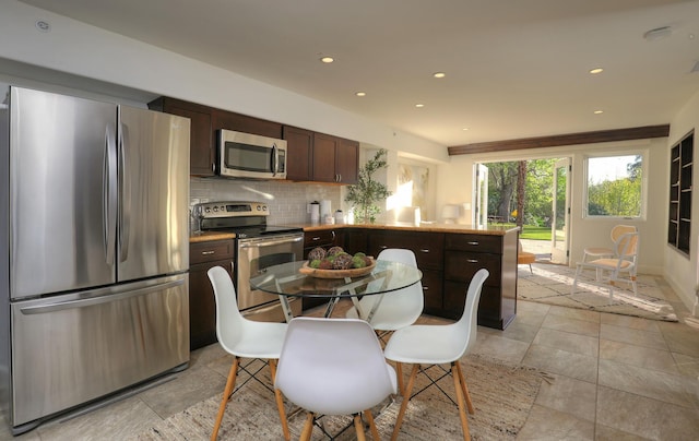 62 Canon View Rd, Montecito, CA 93108 - kitchen with appliances with stainless steel finishes, a peninsula, dark brown cabinetry, tasteful backsplash, and recessed lighting