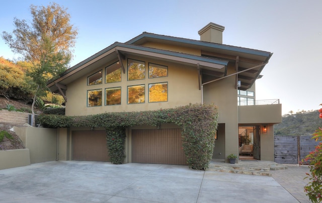 62 Canon View Rd, Montecito, CA 93108 - back of house featuring stucco siding, a balcony, a garage, concrete driveway, and a chimney