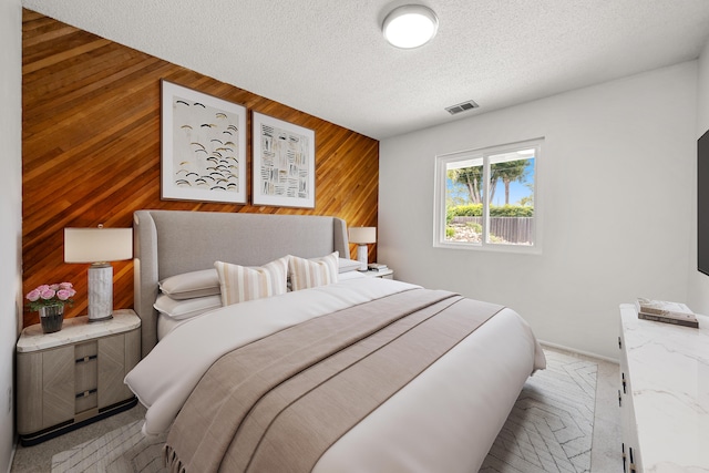 4634 Puente Plz, Santa Barbara, CA 93110 - bedroom with wooden walls, a textured ceiling, and an accent wall