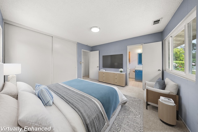 4634 Puente Plz, Santa Barbara, CA 93110 - bedroom with light colored carpet, a textured ceiling, and connected bathroom
