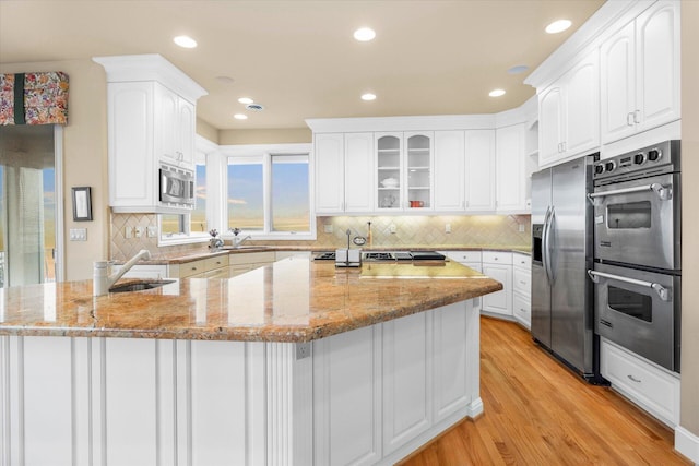 11719 SE Solomon Ct, Happy Valley, OR 97086 - kitchen with stainless steel appliances, a sink, light stone counters, white cabinetry, and recessed lighting