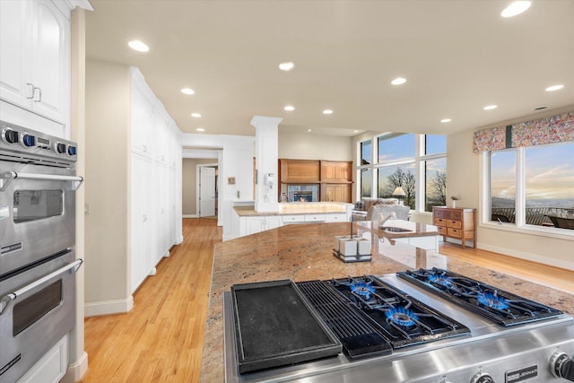 11719 SE Solomon Ct, Happy Valley, OR 97086 - kitchen featuring appliances with stainless steel finishes, light wood-style floors, white cabinetry, baseboards, and recessed lighting