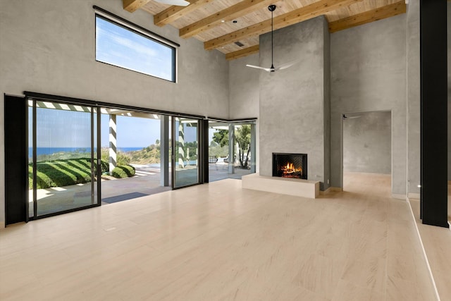 892 Toro Canyon Rd, Montecito, CA 93108 - unfurnished living room featuring a towering ceiling, a wooden ceiling with exposed beams, a high end fireplace, ceiling fan, and wood finished floors