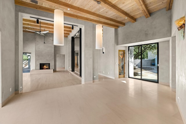 892 Toro Canyon Rd, Montecito, CA 93108 - unfurnished living room with plenty of natural light, a towering ceiling, a wood ceiling with exposed beams, and a fireplace