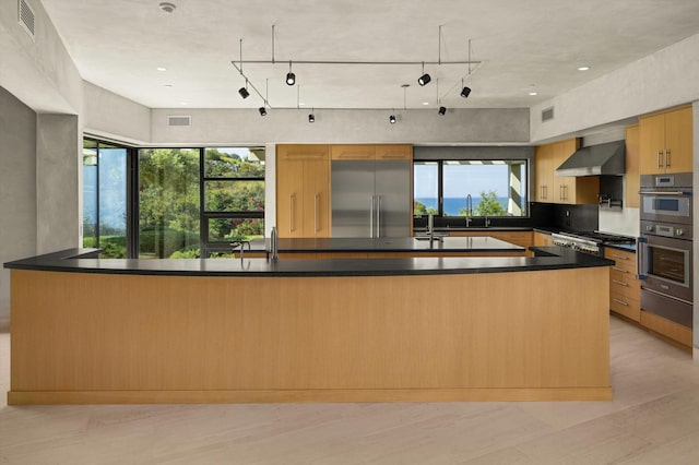 892 Toro Canyon Rd, Montecito, CA 93108 - kitchen featuring stainless steel appliances, healthy amount of natural light, dark countertops, and wall chimney exhaust hood