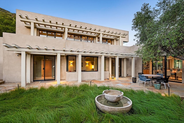 892 Toro Canyon Rd, Montecito, CA 93108 - rear view of house featuring a pergola, a patio, stucco siding, and a balcony