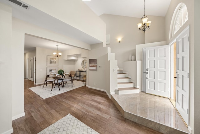 7134 Phelps Rd, Goleta, CA 93117 - entryway featuring a chandelier, high vaulted ceiling, wood finished floors, baseboards, and stairs