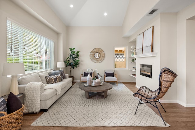 7134 Phelps Rd, Goleta, CA 93117 - living area featuring wood finished floors, baseboards, a glass covered fireplace, recessed lighting, and high vaulted ceiling