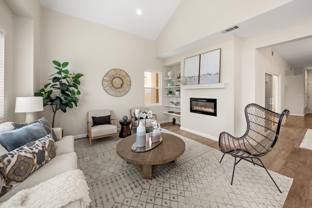 7134 Phelps Rd, Goleta, CA 93117 - living area with built in features, wood finished floors, baseboards, and high vaulted ceiling
