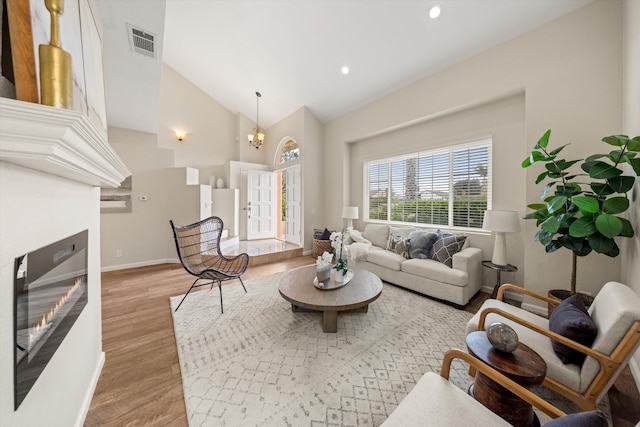 7134 Phelps Rd, Goleta, CA 93117 - living room with a glass covered fireplace, wood finished floors, a chandelier, baseboards, and recessed lighting