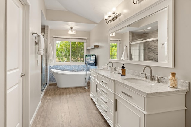 7134 Phelps Rd, Goleta, CA 93117 - full bath with vaulted ceiling, a stall shower, double vanity, wood finished floors, and a freestanding tub