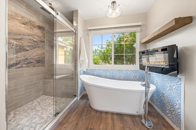 7134 Phelps Rd, Goleta, CA 93117 - full bathroom featuring wood finished floors, a freestanding tub, and a stall shower