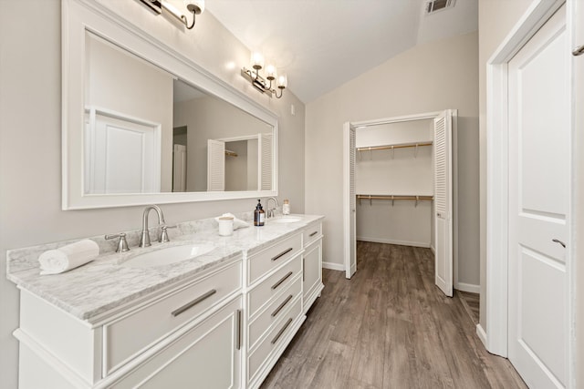 7134 Phelps Rd, Goleta, CA 93117 - full bathroom with lofted ceiling, double vanity, wood finished floors, baseboards, and a spacious closet