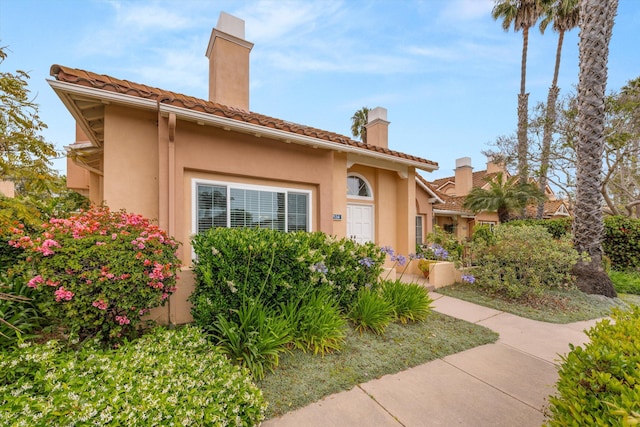 7134 Phelps Rd, Goleta, CA 93117 - view of front facade featuring a chimney, stucco siding, and a tiled roof