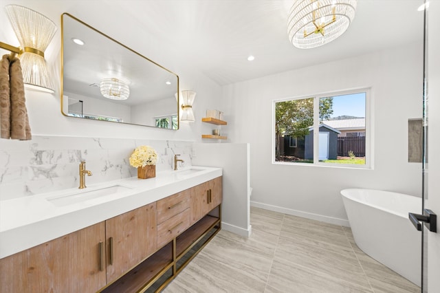 1570 Mountain View Dr, Solvang, CA 93463 - bathroom featuring double vanity, a freestanding tub, tasteful backsplash, recessed lighting, and baseboards
